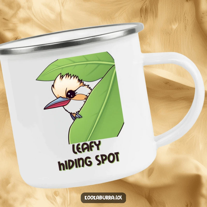 Funny camping mug featuring a kookaburra peeking from behind a leaf, giving a mischievous wink for outdoor fun.