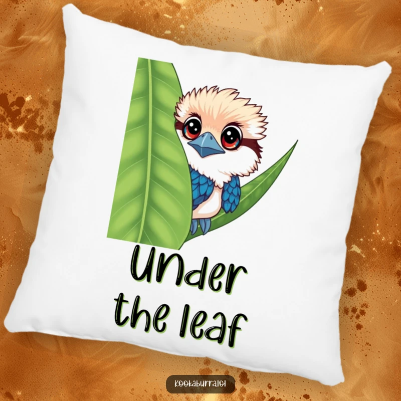 Funny kookaburra pillow featuring a bird with large eyes, peeking from behind a leaf, soft and cute.