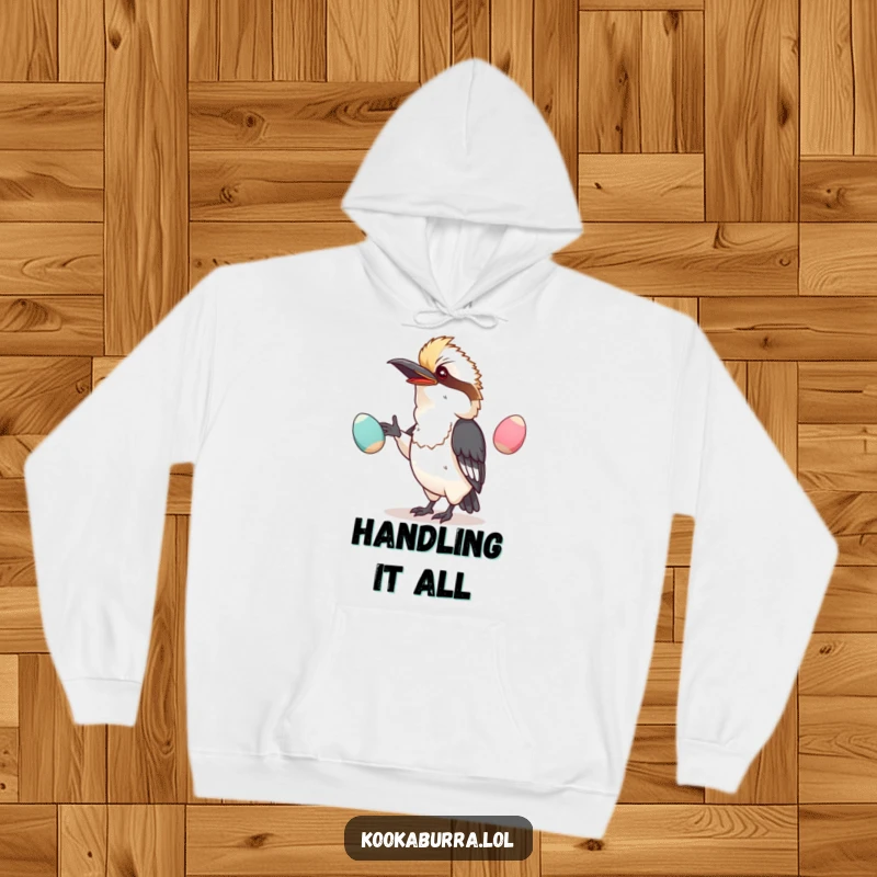 Funny hoodie depicting a kawaii kookaburra engaged in a comical, wobbly egg juggling act, radiating playful humor.